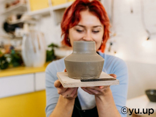 Image of a woman holding a freshly-made pot